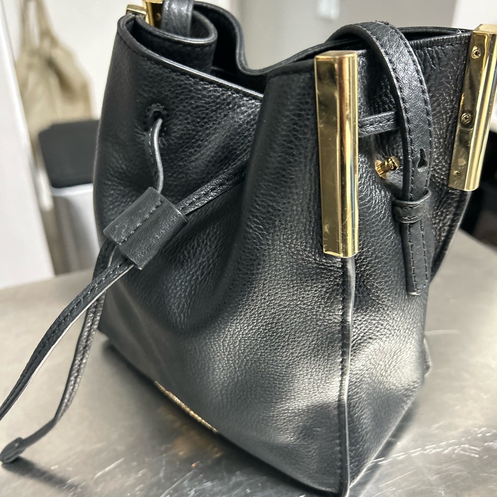 Black Vince Camuto purse with gold hardware.